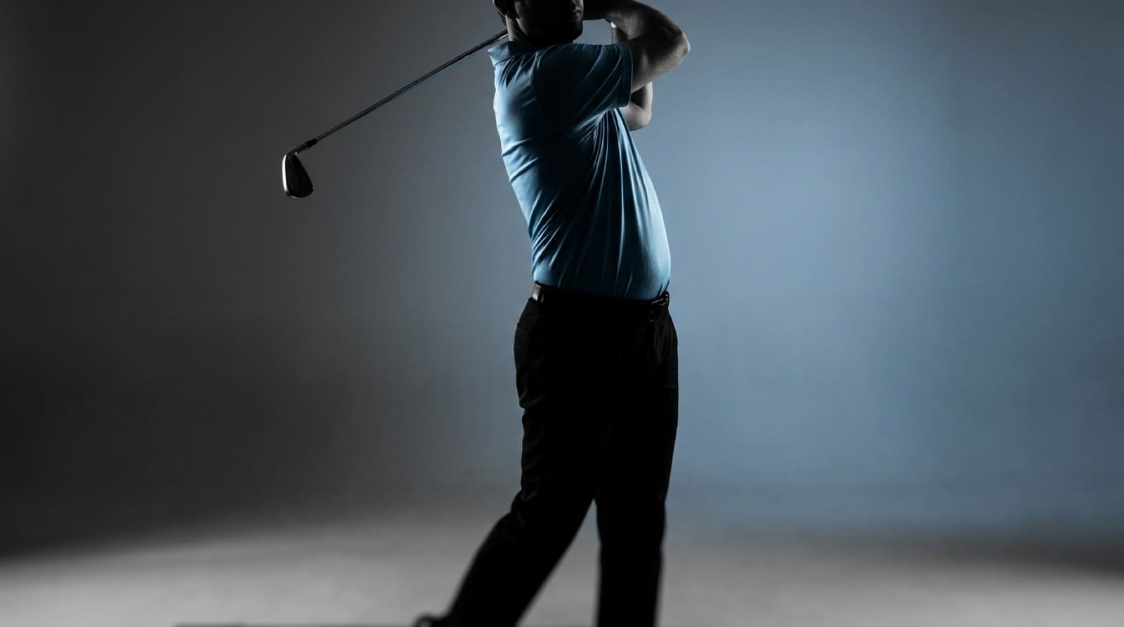 A side-on silhouette of a golfer at the top of the backswing, with a faint line across the shoulders and a second across the hips showing the rotational separation of the X-factor.